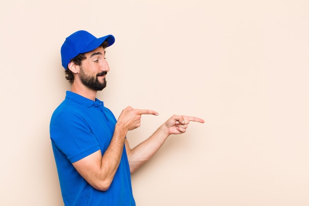 Jeune homme barbu cool pointant vers le côté