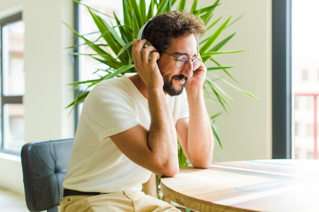 Jeune homme barbu écoute de la musique avec ses écouteurs