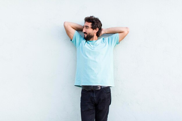 Jeune homme barbu avec un espace de copie de mur blanc vide