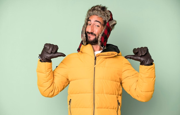 Photo jeune homme barbu et expressif fou concept froid et hiver et portant un anorak