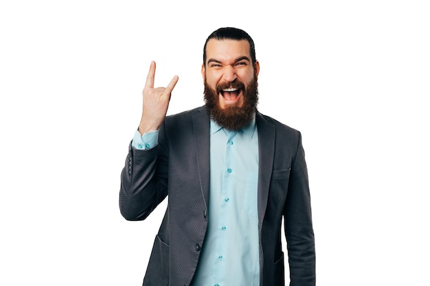 Jeune homme barbu extatique portant une veste montre le geste du rock