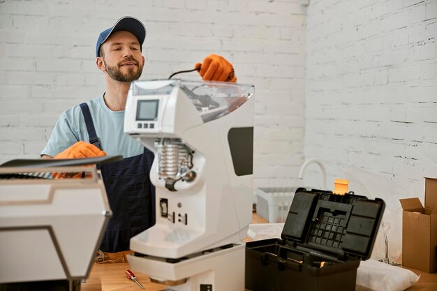 Jeune Homme Barbu Fixant La Machine à Café Au Café