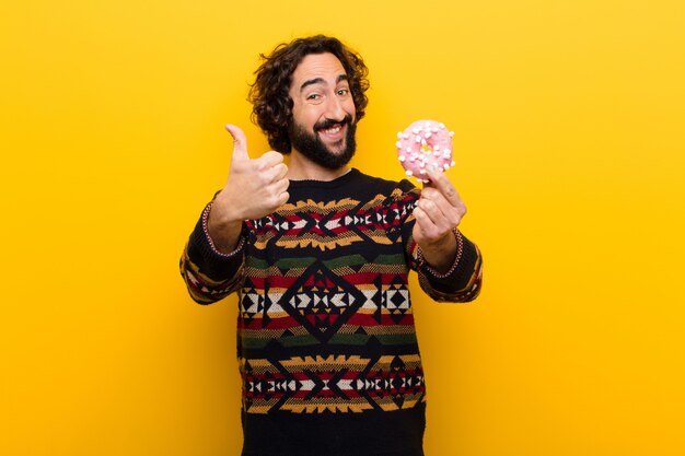 Jeune homme barbu fou avec un beignet de sucre