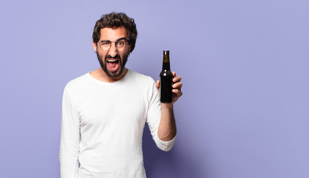 Jeune homme barbu fou avec une bière