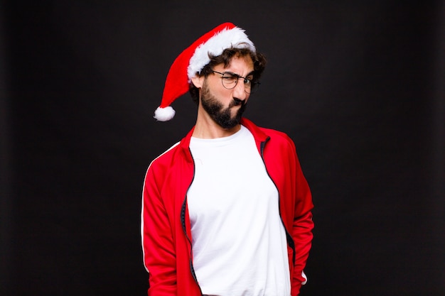 Jeune homme barbu fou avec Bonnet de Noel. Concept de noel