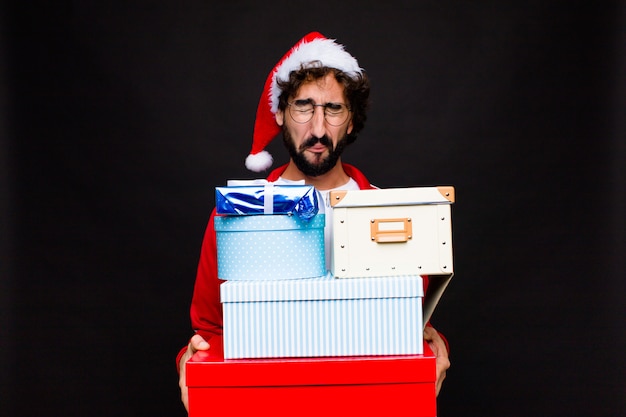 Jeune homme barbu fou avec Bonnet de Noel. Concept de noel