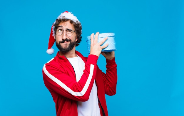 Jeune homme barbu fou avec Bonnet de Noel. Concept de noel