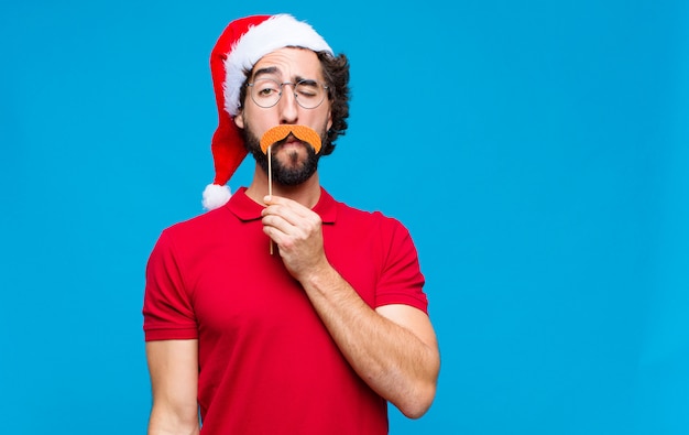 Jeune homme barbu fou avec Bonnet de Noel. Concept de noel