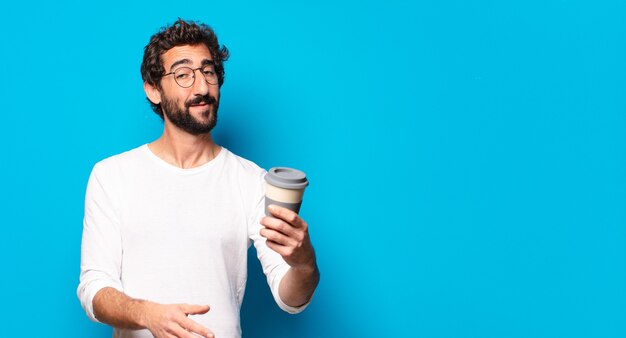 Jeune homme barbu fou avec un café à emporter