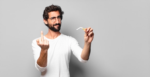 Photo jeune homme barbu fou avec une cigarette. pas de concept de fumer.