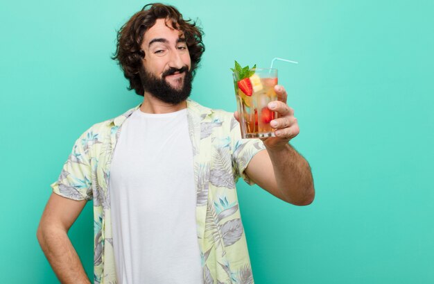 Jeune homme barbu fou avec un cocktail. concept touristique