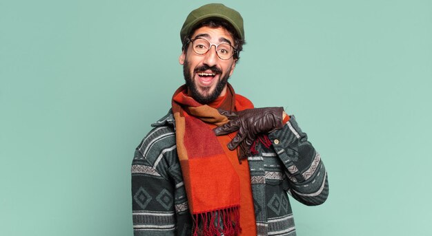 Jeune homme barbu fou expression fière et portant des vêtements d'hiver