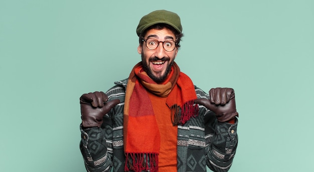 Jeune homme barbu fou expression fière et portant des vêtements d'hiver