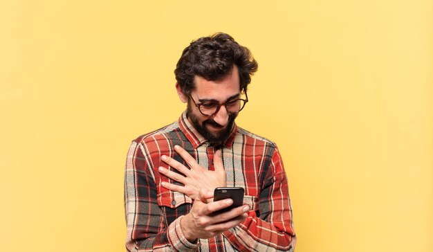 Jeune homme barbu fou expression heureuse et tenant un téléphone