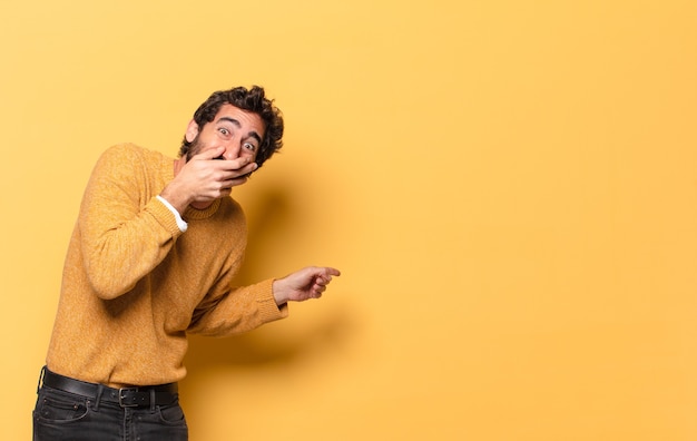 Jeune homme barbu fou exprimant avec un espace de copie.