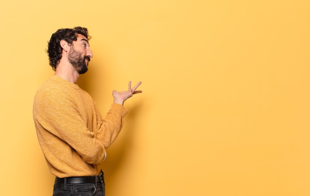 Jeune homme barbu fou exprimant avec un espace de copie.