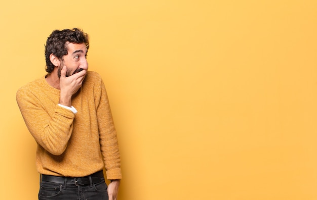 Jeune homme barbu fou exprimant avec un espace de copie.