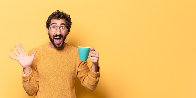 Jeune homme barbu fou avec une tasse de café