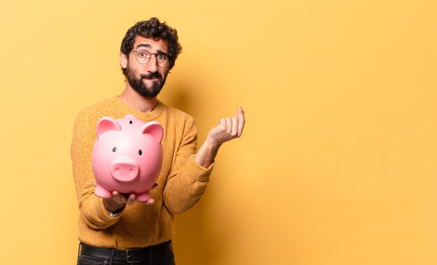 Jeune homme barbu fou avec une tirelire