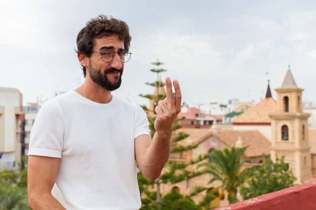 Jeune homme barbu fumant une cigarette