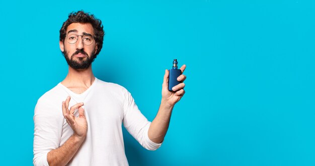 Jeune homme barbu fumant avec un vaper