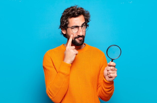 Photo jeune homme barbu avec une loupe