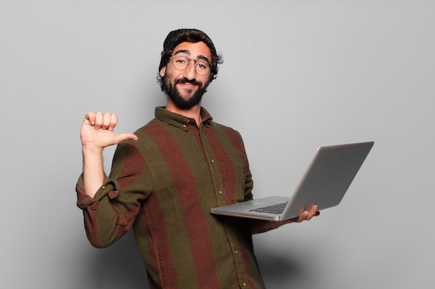 Jeune homme barbu avec un ordinateur portable