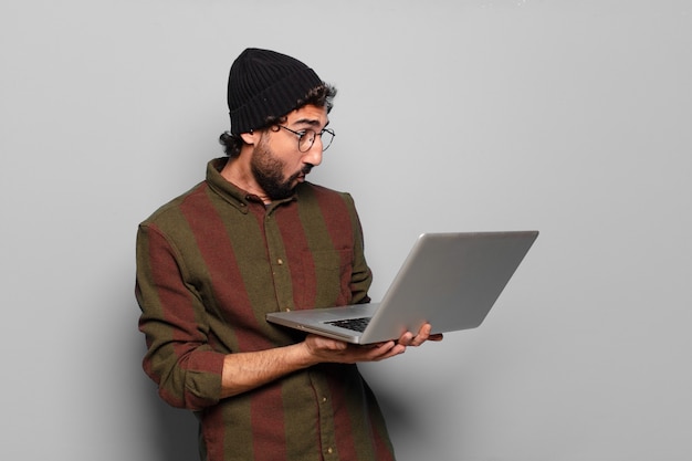 Jeune homme barbu avec un ordinateur portable