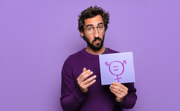 Jeune homme barbu avec papier sur l'égalité des sexes