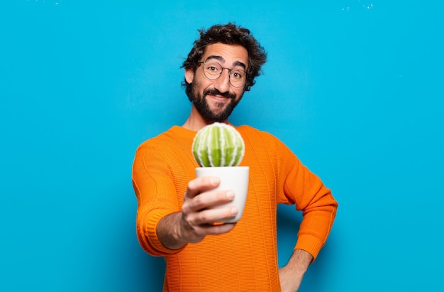 Jeune homme barbu avec une plante de cactus