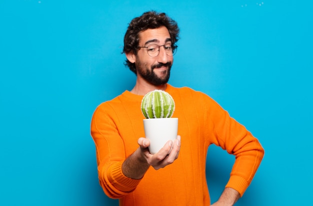 Jeune homme barbu avec une plante de cactus