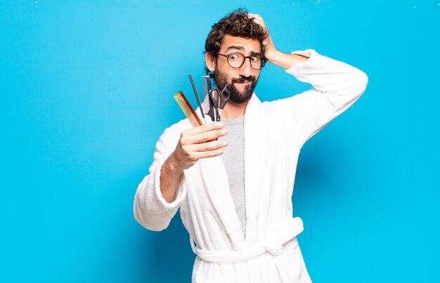 Jeune homme barbu portant un peignoir. concept de soins de cheveux ou de barbe