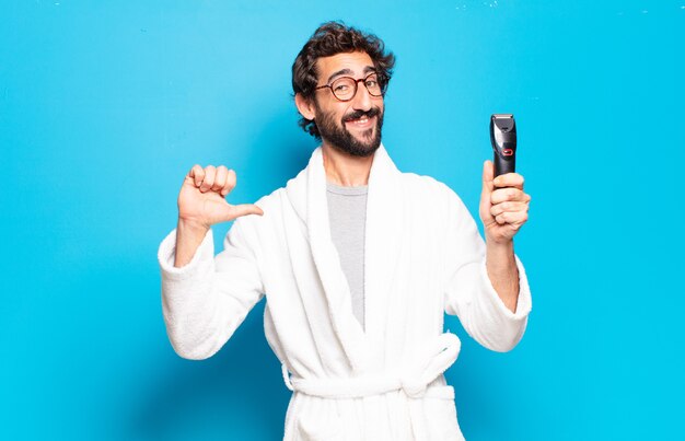 Jeune homme barbu portant un peignoir. concept de soins de cheveux ou de barbe