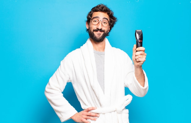 Jeune homme barbu portant un peignoir. concept de soins des cheveux ou de la barbe