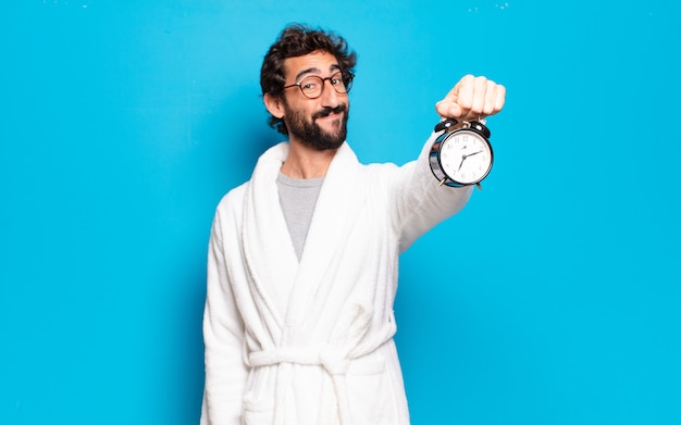 Photo jeune homme barbu portant un peignoir et un réveil