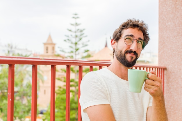 Jeune homme barbu prenant un café