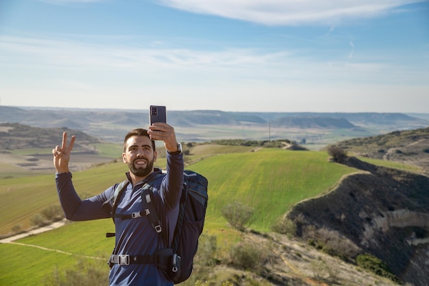 Jeune homme barbu prenant un selfie avec son mobile