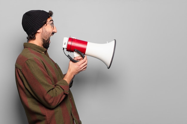 Jeune homme barbu protestant avec un mégaphone