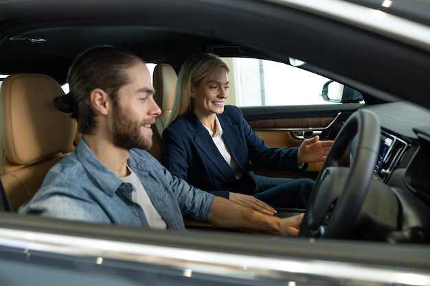 Un jeune homme barbu qui regarde excité alors qu'il est assis dans une voiture avant le test-drive