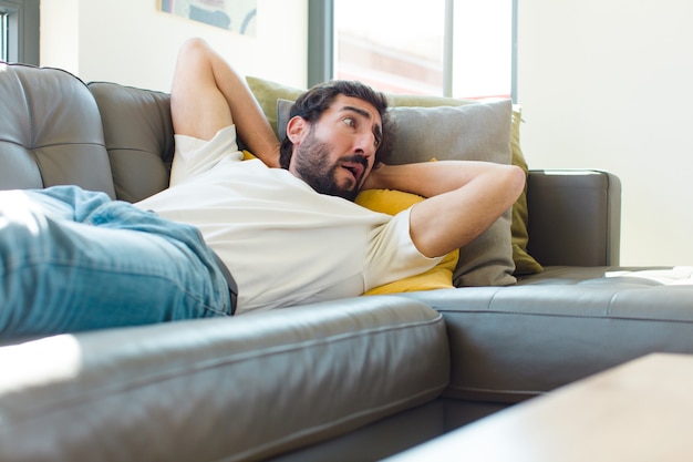 Jeune homme barbu reposant sur un canapé