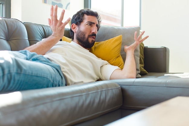 Jeune homme barbu se reposant sur un divan