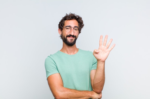 Jeune homme barbu souriant et à la sympathique, montrant le numéro quatre