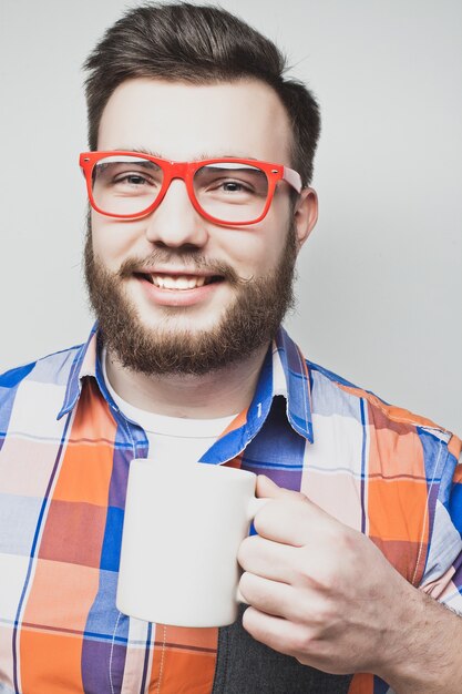 Jeune homme barbu avec une tasse de café