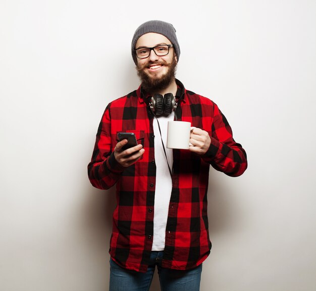 Jeune homme barbu avec téléphone portable