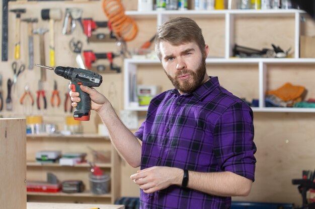 Jeune homme barbu travaillant à l'usine de meubles