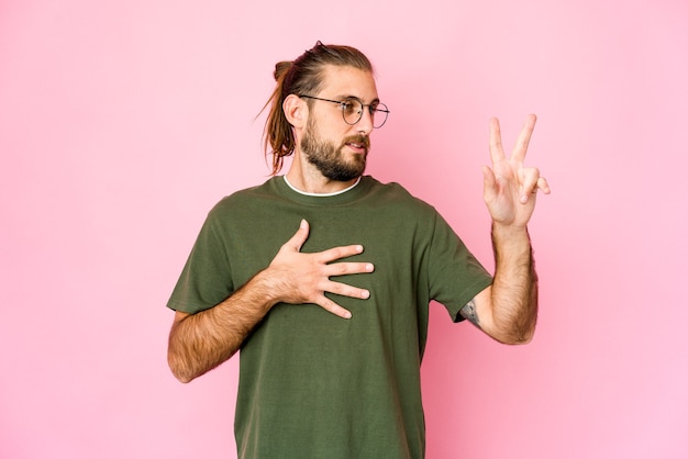 Jeune homme beau caucasien cheveux longs exprimant des émotions isolées