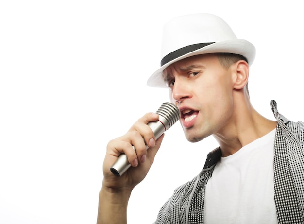 Un jeune homme beau chante avec un micro.