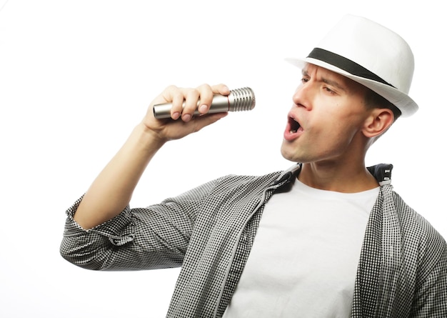 Un jeune homme beau chante avec un micro.