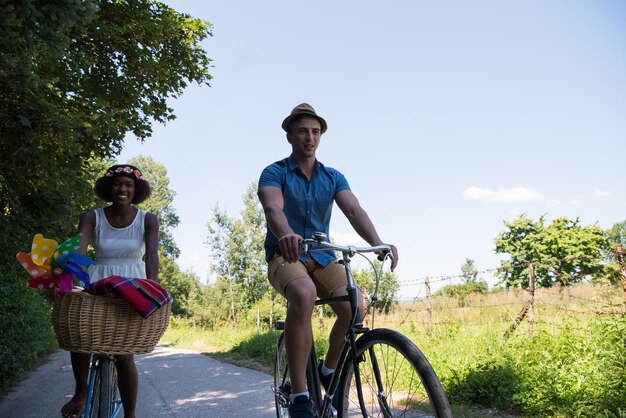 un jeune homme et une belle fille afro-américaine profitant d'une balade à vélo dans la nature par une journée d'été ensoleillée