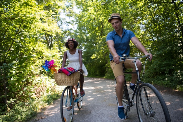 un jeune homme et une belle fille afro-américaine profitant d'une balade à vélo dans la nature par une journée d'été ensoleillée